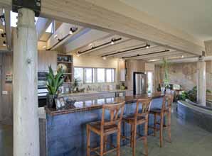 Well-lit kitchen with breakfast bar in a poured earth home located in Prescott, AZ